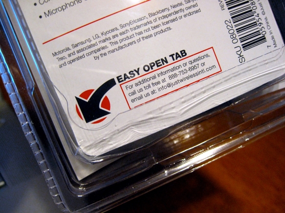 Easy open tab on the backside of a sealed plastic clamshell package.